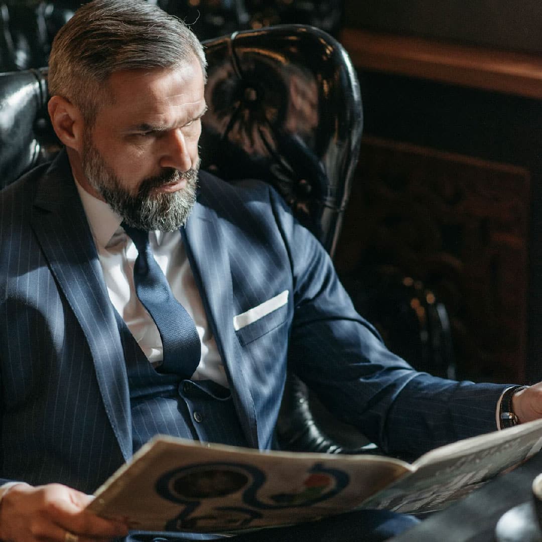 Wealthy man reading a newspaper for the Fortis Arbor Wealth verbal identity review project.
